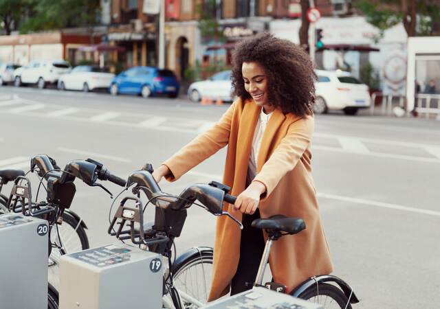 Woman in urban station with electric bicycles