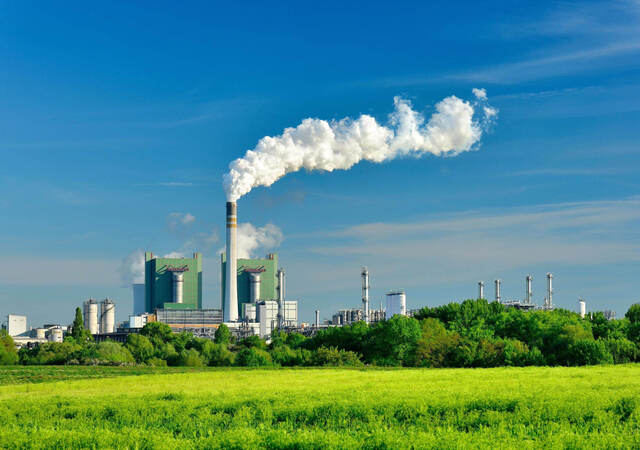 Steaming ignite-fired power plant in a green landscape