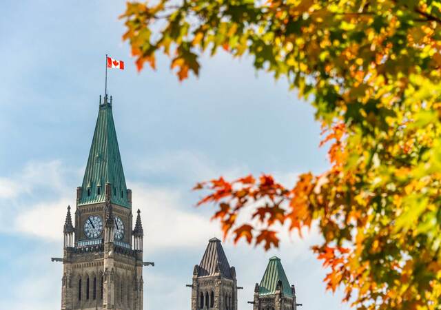 Peace Tower of the Canadian Parliament with autumn foliage in Ottawa