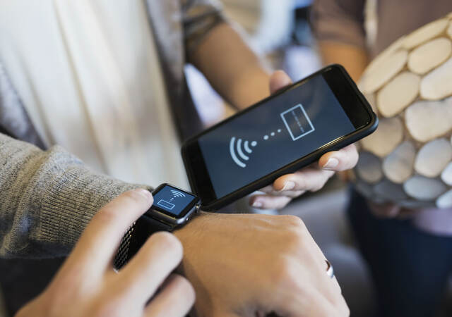 A person pairing up a cellphone and smart watch