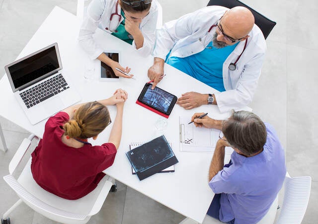 Medical team sitting and discussing at table.