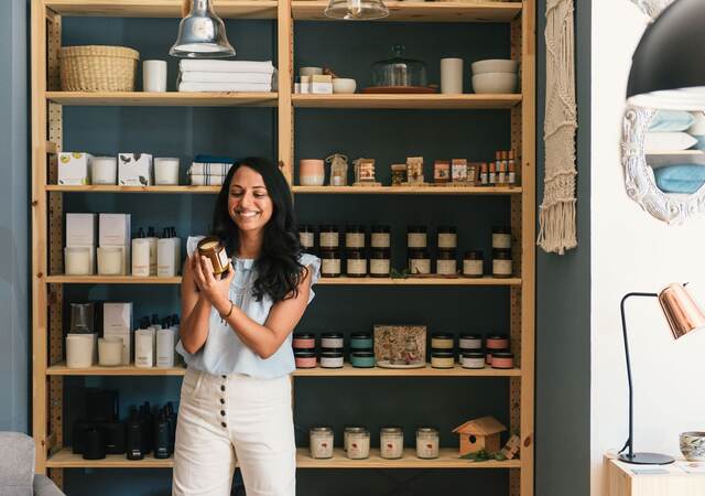 Stylish woman shopping in fragrance and beauty section of home store.