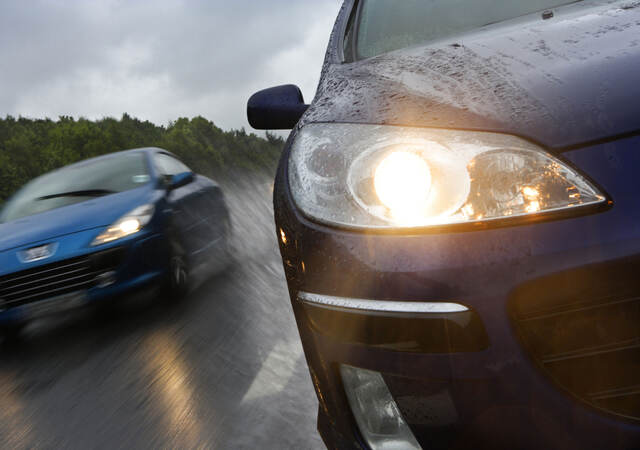 Two cars driving in the rain