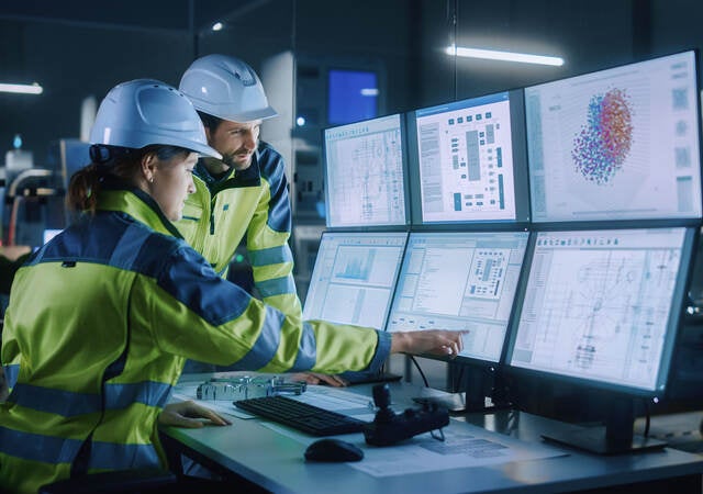 Project engineer talks to female operator who controls facility production line.