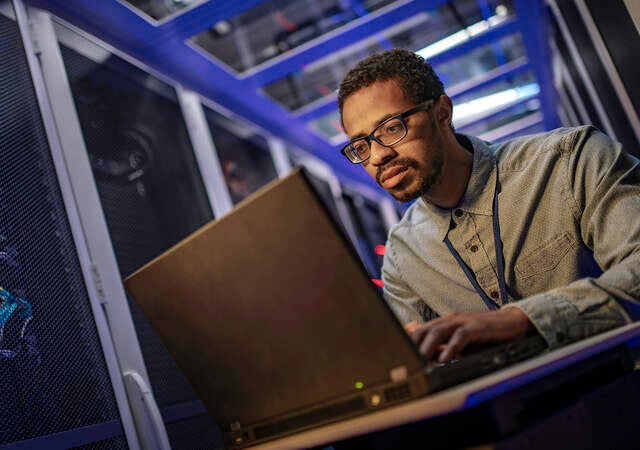 IT engineer using a computer in the server room