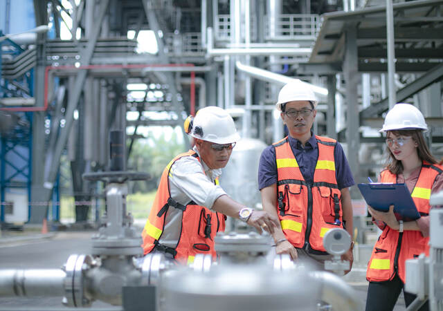 Pipeline oil engineers having a discussion in a factory