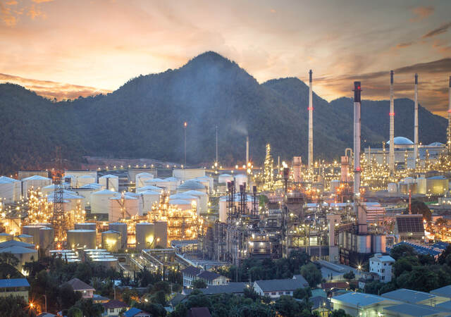 Oil refinery, aerial petrochemical storage tanks with refining industrial floor, oil refinery at night.