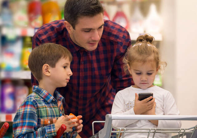 Family at a store looking at a smartphone while shopping