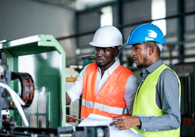 African Businessmen and Production Manager during meeting with production scheduling plan in a factory.