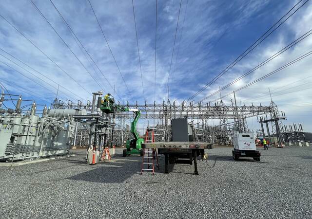 Worker inspecting high voltage cables.