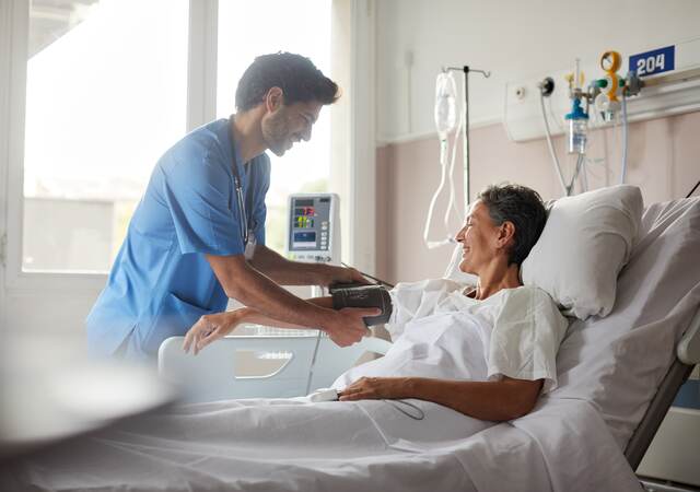 Nurse taking pulse of patient.