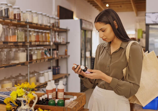 Person reading a label on a product while shopping in a store