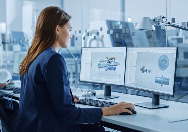 Portrait of Young and Confident Industrial Engineer Working on Computer, on Screen CAD Software Showing New Generation Electric Engine.