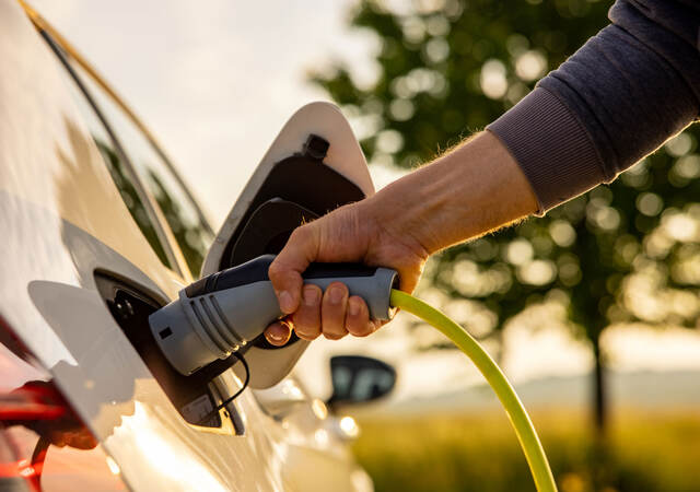 A person charging an electric vehicle