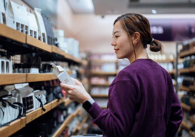 A person looking at the ingredients of the skincare package