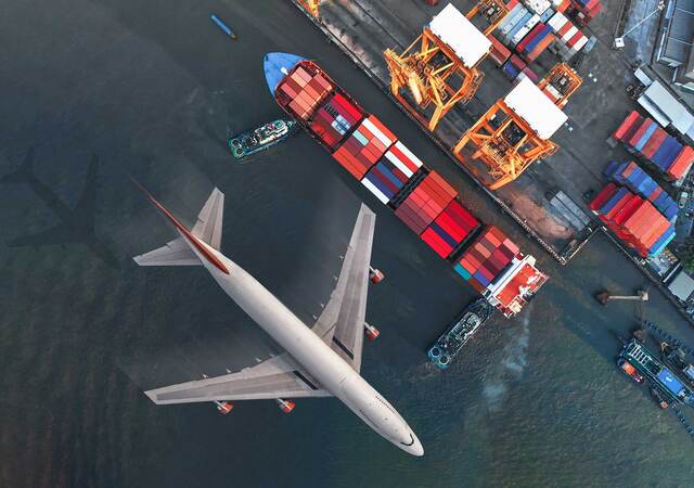 Plane flying over a shipyard