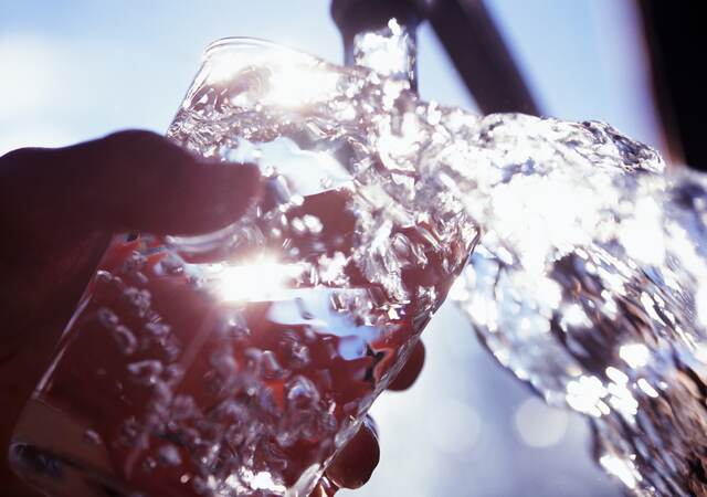 Filling glass with water.