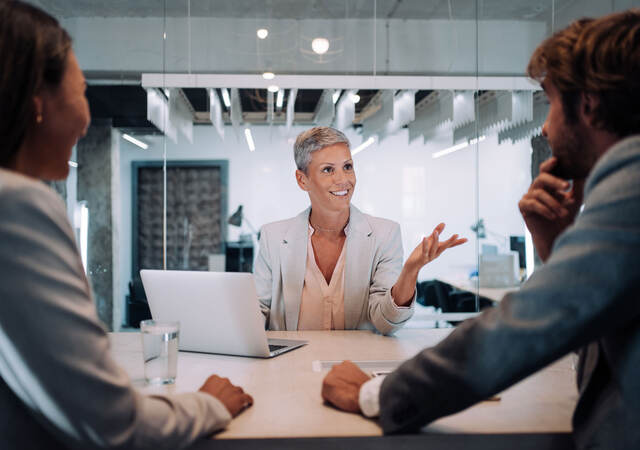 Three business people at a table having a meeting