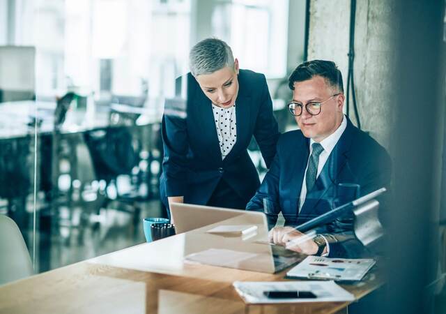 Two business colleagues collaborating over a laptop