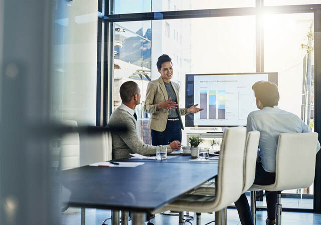 Three business colleagues reviewing metrics in a meeting