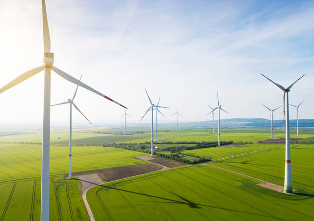 Sun shining over wind turbines on a wind farm