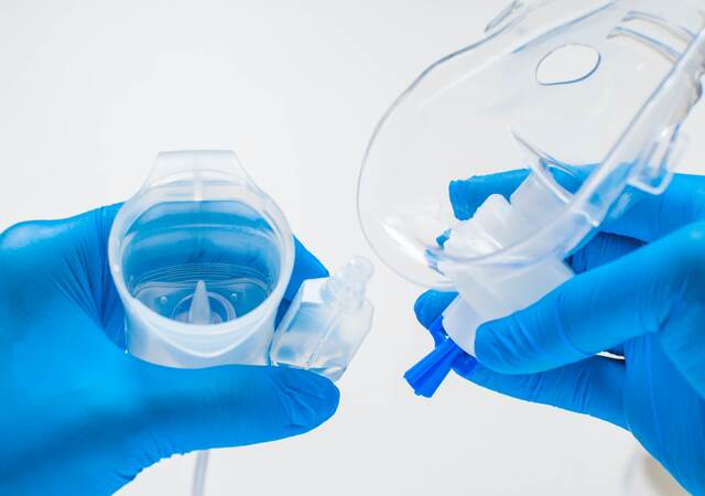 A young healthcare worker is preparing an asthma nebulizer.