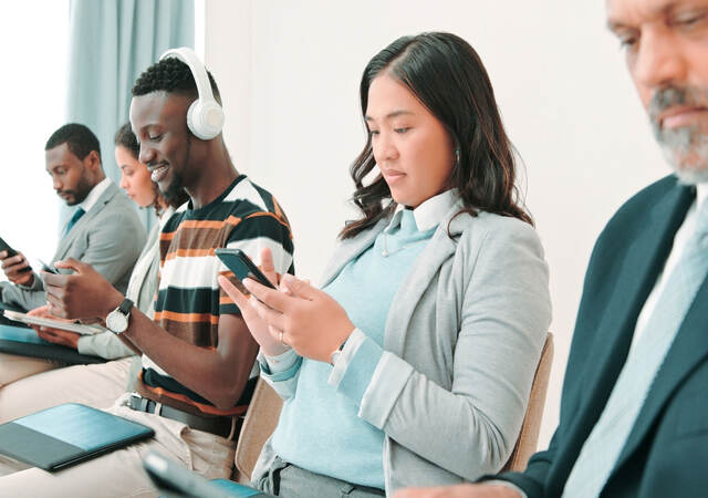 People in a waiting room and using mobile devices