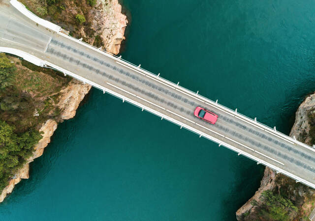 Overhead view of a car going across a bridge