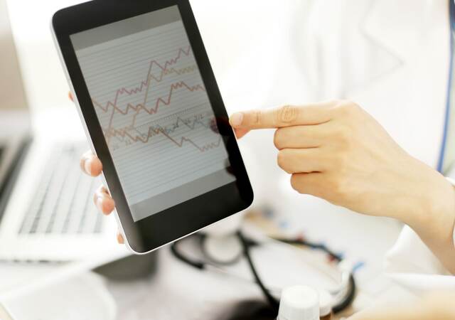 Doctor hands hold and show digital tablet pc to patient.