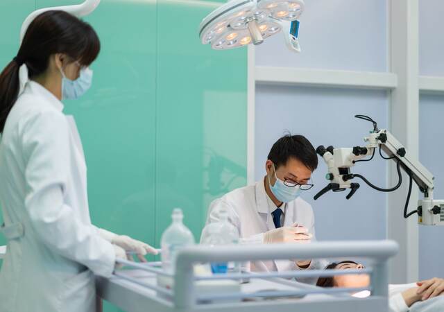 Doctor and nurse operating on female patient