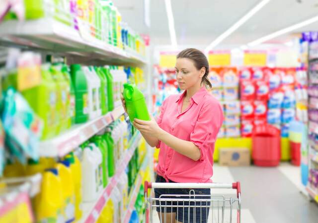 Person reading a label on a product while shopping in a store