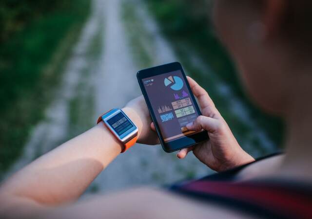 Man using smart phone and smart watch outside