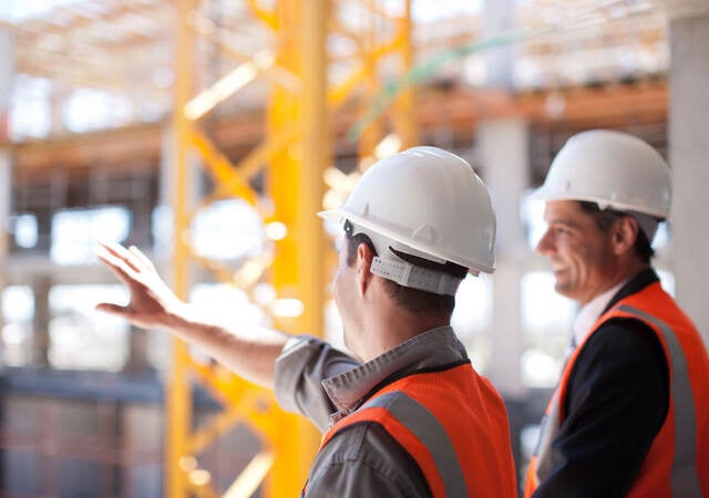 An engineer and architect overlook the construction of a new commercial building