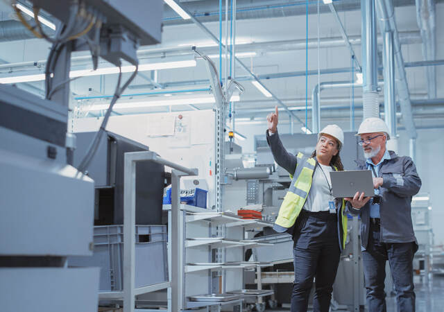 Two managers inspecting and discussing an industrial facility