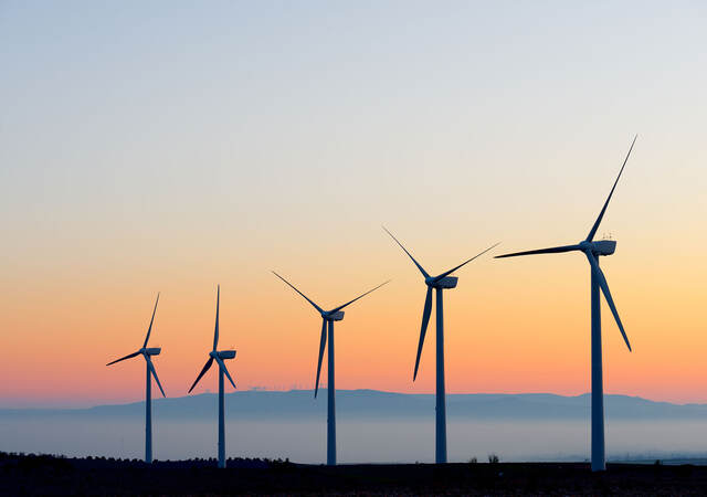 A line of wind turbines at dusk