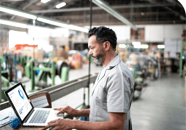 person on laptop in factory