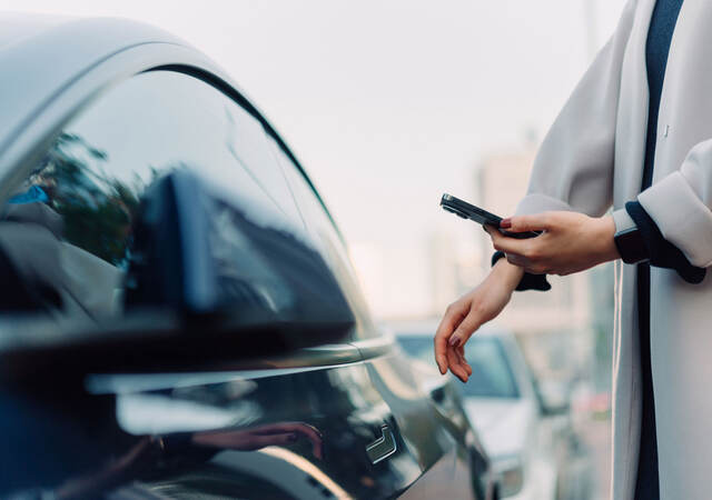 A person looking at an app for their smart vehicle