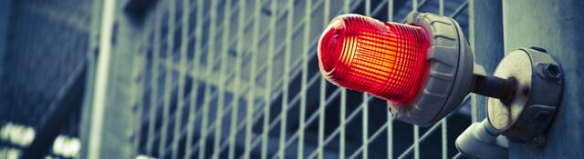 A red emergency light over a commercial building door.