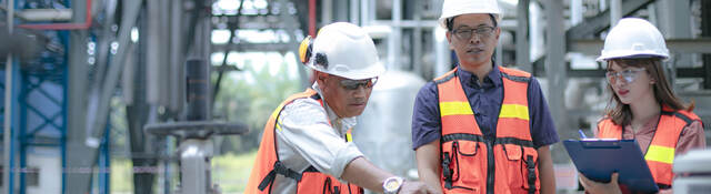 Pipeline oil engineers having a discussion in a factory