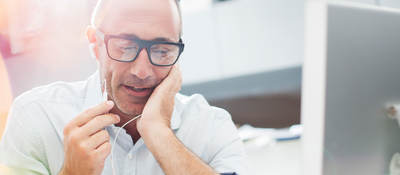 image of a man talking on a phone near a computer