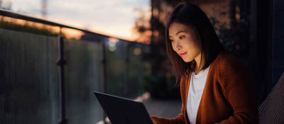 Woman using a laptop at dusk