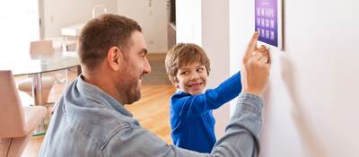 Father and his child are touching a IoT device.