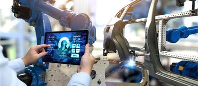 man holding tablet by car chasis