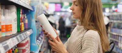 Person reading a label on a product while shopping in a store