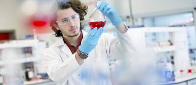 Chemistry research student working in laboratory.