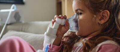 Young child using nebulizer during inhaling therapy