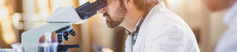 Scientist looking through a microscope