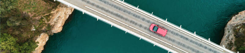 Overhead view of a car going across a bridge