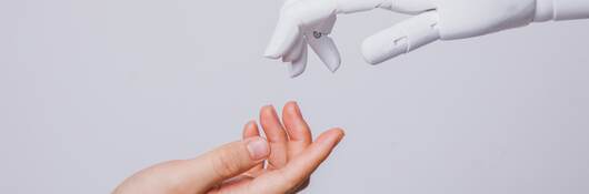 Human hand reaching for robotic hand.