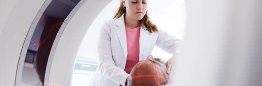 radiologist helping patient in medical x-ray scanner